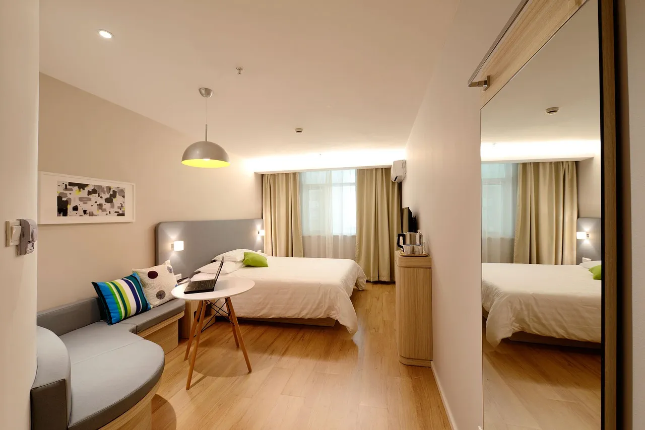 Bright guest room in an accommodation property with bed, sofa and desk by the window